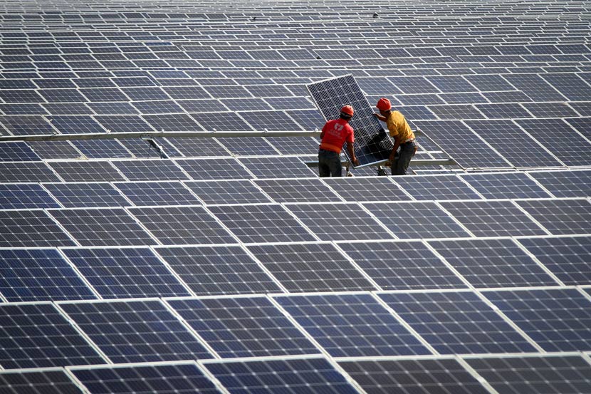 Рабочие собирают солнечные батареи на электростанции в Хуайане, провинция Цзянсу, 23 июня 2018 года. Чжоу Чанго / VCG